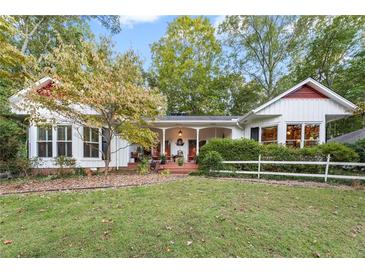 Charming home featuring a well-manicured lawn and a welcoming front porch with cozy seating at 6791 Yacht Club Dr, Acworth, GA 30102