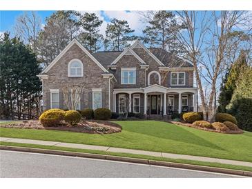 Charming two-story brick home with well-manicured lawn and inviting front porch, a perfect suburban oasis at 406 Greyfield Dr, Canton, GA 30115