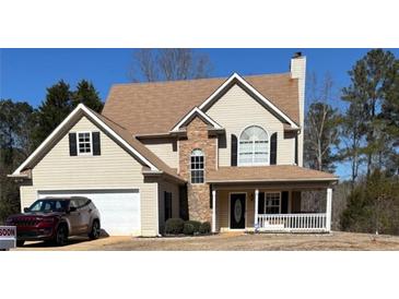 Charming two-story home featuring a front porch, attached garage, and stone accents at 190 The Falls Blvd, Covington, GA 30016