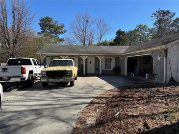 Charming single-story home featuring a covered porch and an attached garage with driveway parking at 2408 Three Bars Dr, Snellville, GA 30078