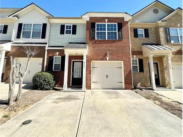 Charming brick townhouse with a one-car garage and a welcoming front entrance and driveway at 2795 Greenbridge Drive, Norcross, GA 30071