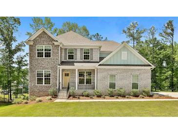 Charming two-story home featuring a mix of brick and stone facade, complemented by a well-manicured lawn at 135 Eastmark Way, Fayetteville, GA 30214