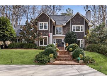 Charming two-story home with manicured front lawn and brick stairs leading to a welcoming front entrance at 5575 Glen Errol Rd, Sandy Springs, GA 30327