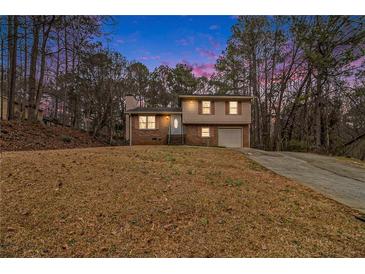Charming two-story brick home with a well-maintained front yard and an attached single car garage at 620 Bell Se Rd, Conyers, GA 30094
