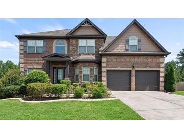 Charming brick home with a well-manicured front lawn and two-car garage at 4249 Caveat Ct, Fairburn, GA 30213