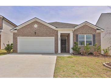 Charming one-story brick home with a two-car garage and a well-maintained front yard at 1991 Vidalia Ct, Dacula, GA 30019