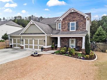Charming two-story home featuring stone accents, a well-manicured lawn, and a three-car garage at 108 Summer Breeze Ln, Canton, GA 30114