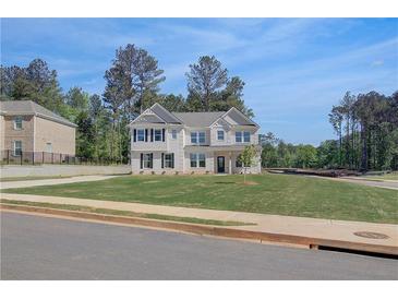 Two-story home featuring black shutters, white siding, and a well-manicured lawn at 141 Frontier Way, Mcdonough, GA 30253