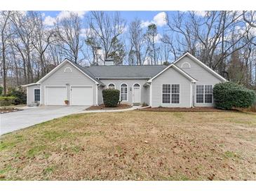 Charming single-story home with gray siding, arched windows, attached garage, and landscaped front yard at 1925 Emerald Dr, Cumming, GA 30040