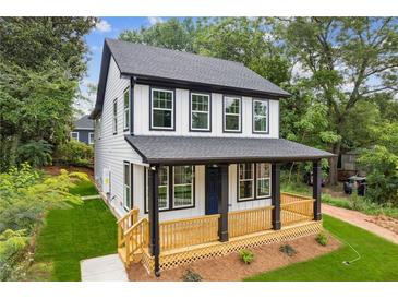 Charming two-story home with a welcoming front porch and freshly manicured lawn at 1158 Welch Sw St, Atlanta, GA 30310