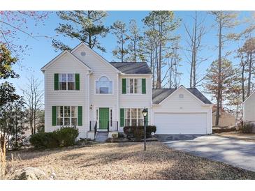Charming two-story home with green shutters, a well-manicured lawn, and a two-car garage at 1056 Shadow Lake Dr, Lithonia, GA 30058