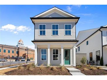 Charming two-story home with a manicured front yard and a striking green front door at 108 Black Gum Unit 38 Ln, Auburn, GA 30011