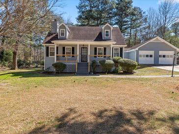 Charming home features a cozy front porch and detached two-car garage at 150 Forest Ridge Ct, Lawrenceville, GA 30046