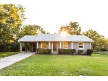 Charming single-story home featuring a covered carport and a well-manicured lawn at 391 Oak Dr, Social Circle, GA 30025