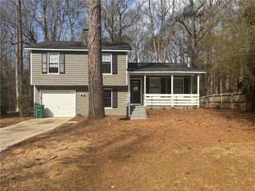 Charming two-story home featuring a front porch and attached garage at 885 Hemingway Rd, Stone Mountain, GA 30088