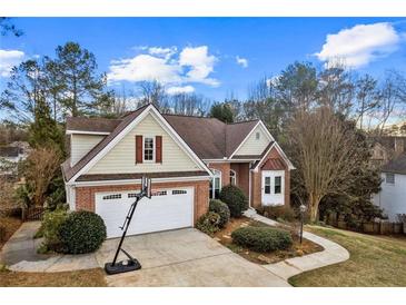 Charming two-story home with brick facade, attached garage, driveway with basketball hoop, and professionally landscaped yard at 635 Piping Rock Pt, Lawrenceville, GA 30043