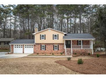Charming two-story home with brick accents, front porch, two-car garage, and well-manicured landscaping at 1106 Oak Sw Rd, Lilburn, GA 30047