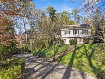 Charming two-story home featuring black shutters and a stone foundation, nestled on a well-manicured, tree-lined lot at 3200 Wood Valley Nw Rd, Atlanta, GA 30327