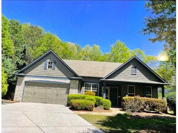 Charming single-story home with a two-car garage, stone accents, and a well-manicured front yard at 1315 Thunder Gulch Pass, Suwanee, GA 30024