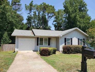 Charming single-story home featuring a well-manicured lawn, mature trees, and an attached garage at 204 Sherwood Loop, Mcdonough, GA 30253