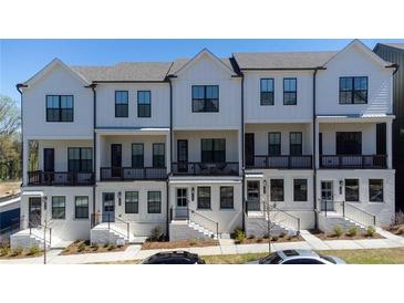 Charming townhome exterior featuring a white facade, black framed windows, and covered porches at 1408 Cozy Court # 303, Atlanta, GA 30315