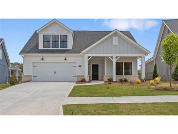 Charming one-story home with a two-car garage, well-manicured lawn, and inviting front porch at 325 Sassafras W Way, Holly Springs, GA 30115