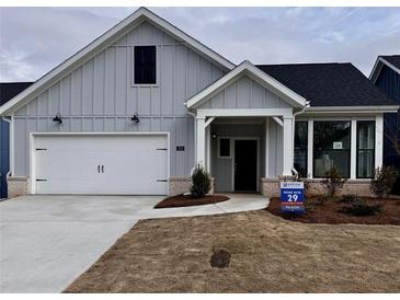 Charming single-Gathering home featuring board and batten siding, a two-car garage, and a covered front porch at 325 Sassafras W Way, Holly Springs, GA 30115