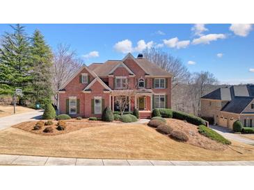 Beautiful two-story brick home with manicured lawn and mature landscaping at 586 Devon Brooke Dr, Woodstock, GA 30188