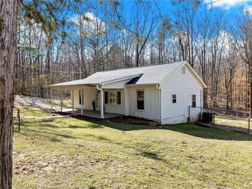 Charming single-story home featuring a covered porch, white siding, and a fenced yard at 6734 Pass Road, Buford, GA 30518