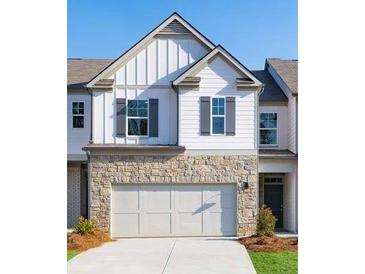 Charming townhome featuring a stone veneer, white siding, gray shutters and a two car garage at 2429 Bayberry St, Acworth, GA 30101