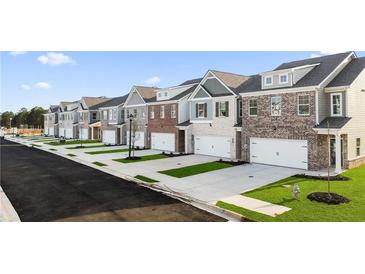 Street view of new construction townhomes with attached garages and manicured lawns at 7021 Old Bridge Ln, Conyers, GA 30013