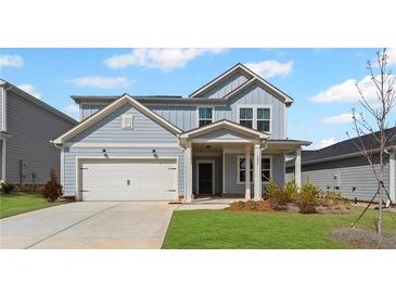 Charming two-story home with a covered front porch, a two-car garage, and a well-manicured lawn at 3071 Birdsong Ave, Covington, GA 30016