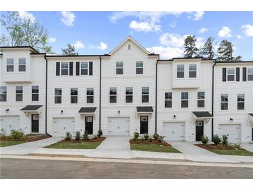 Modern townhomes feature white exteriors, individual garages, and neatly landscaped front yards at 3160 Washburn Sw St, Atlanta, GA 30354