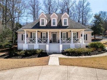 Charming two-story home featuring a covered front porch, dormer windows, and manicured landscaping at 3345 Highgate Hills Ne Dr, Duluth, GA 30097