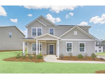 Charming two-story home with a covered front porch, gray siding, and a well-maintained lawn at 3639 Olive Grove Ln, Covington, GA 30016