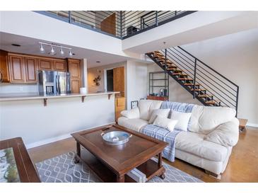 Inviting living room features stairs, loft and open kitchen with stainless steel appliances and breakfast bar at 1133 Church Se St # 2, Covington, GA 30014