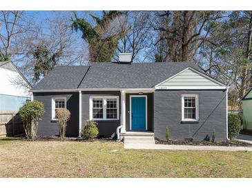 Charming single-story home with a gray brick exterior, bright blue front door, and well-maintained landscaping at 1802 S Gordon Sw St, Atlanta, GA 30310