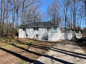 Charming white-painted house with a new driveway and a inviting porch at 5718 Denson Blvd, Morrow, GA 30260