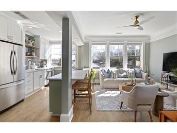 Bright living space featuring a modern kitchen, a living room with natural light, and hardwood floors at 301 10Th Ne St # 15, Atlanta, GA 30309