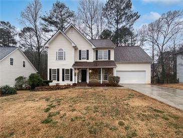 Charming two-story home with stone accents, attached garage, and well-maintained lawn at 662 Springtor Dr, Lawrenceville, GA 30043