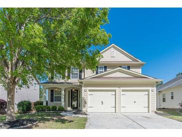 Charming two-story home featuring a well-manicured lawn, mature trees, and a convenient two-car garage at 4310 Alysheba Dr, Fairburn, GA 30213
