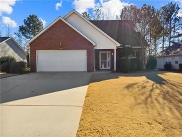 Charming single-story brick home featuring an attached two-car garage and a well-maintained front yard at 122 Sanders Walk, Mcdonough, GA 30252