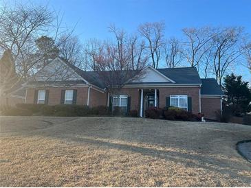 Charming brick home featuring a well-maintained lawn and inviting curb appeal at 1415 Fountain Cove Ln, Lawrenceville, GA 30043