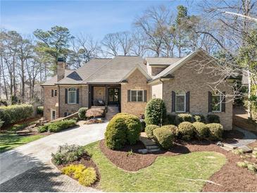 Charming brick home features a well-manicured lawn and a welcoming front porch at 3979 Sentry Xing, Marietta, GA 30068