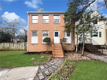 Charming brick home featuring a well-manicured front yard and inviting walkway to the front door at 1444 Twin Branches Se Cir, Marietta, GA 30067