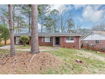 Charming single-story brick home featuring a covered carport, mature trees, and a well-maintained lawn at 2458 Kelly Lake Dr, Decatur, GA 30032