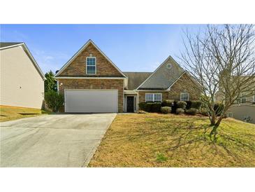 Charming home featuring stone accents, a two-car garage, and well-maintained landscaping at 1710 River Mill Ne Trl, Conyers, GA 30012