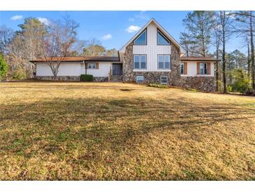 Exterior view of a home featuring stone and siding with a large front yard at 3222 Bay View Dr, Jonesboro, GA 30236