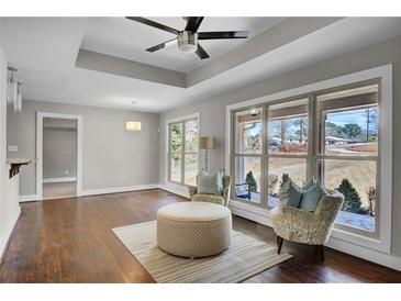 Open-concept living room with hardwood floors, tray ceiling, lots of windows, and stylish furnishings at 1988 Boulderview Se Dr, Atlanta, GA 30316