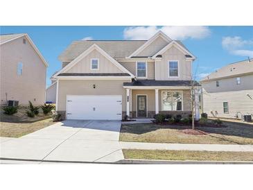 Charming two-story home with a well-maintained lawn and an attached two-car garage at 7783 Hansel Ln, Lithonia, GA 30058
